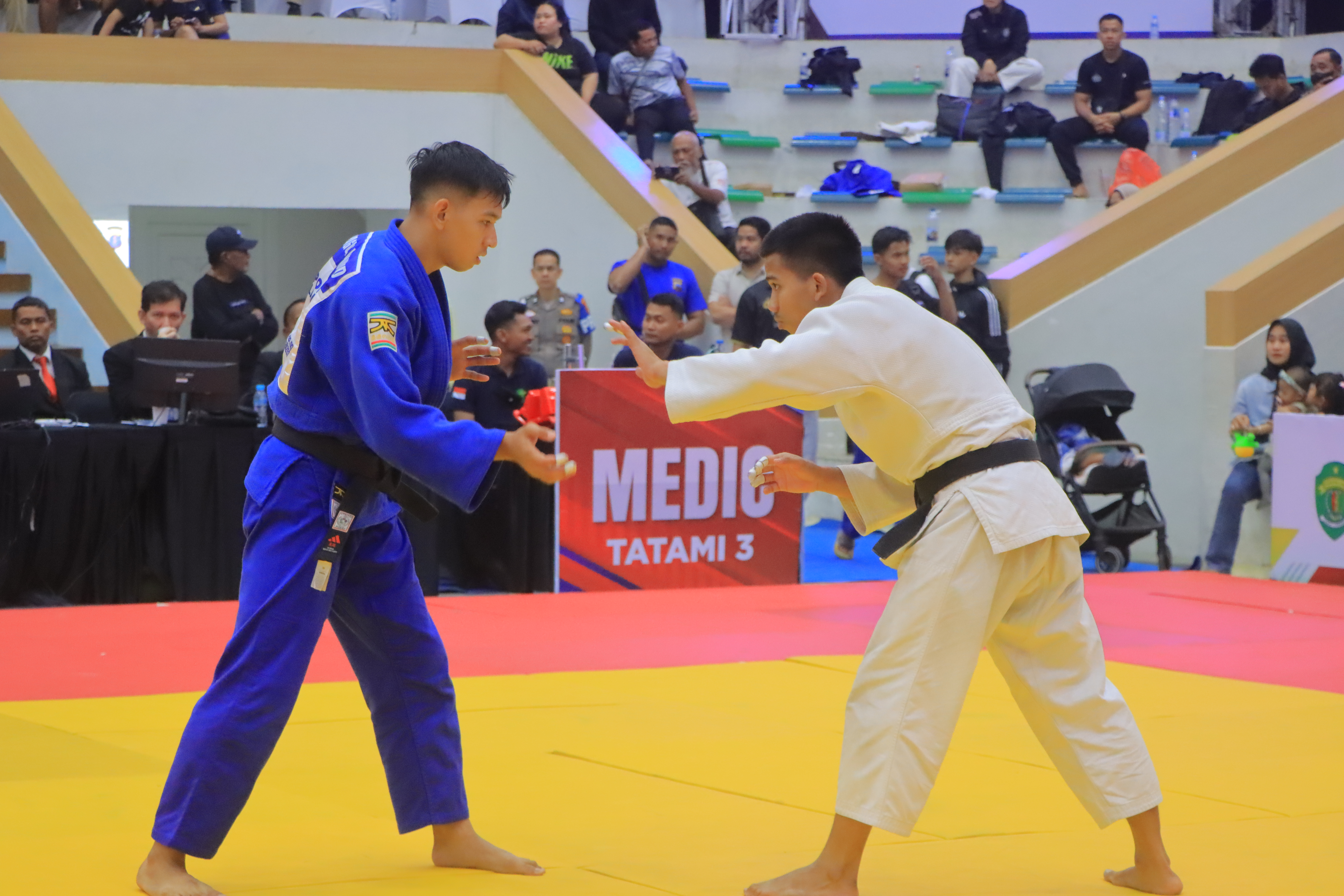 Dua atlet judo memperebutkan kumikata di Tatami 3
